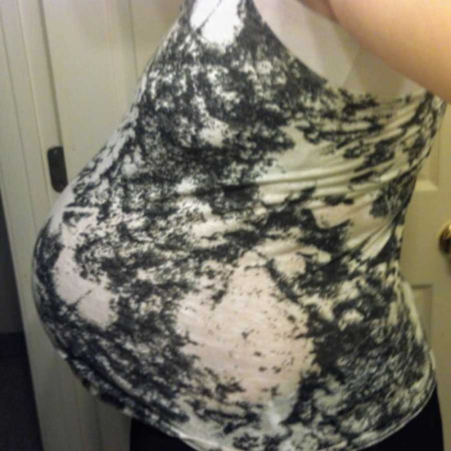 Close up of pregnant woman's stomach who is wearing black and white tie dye shirt
