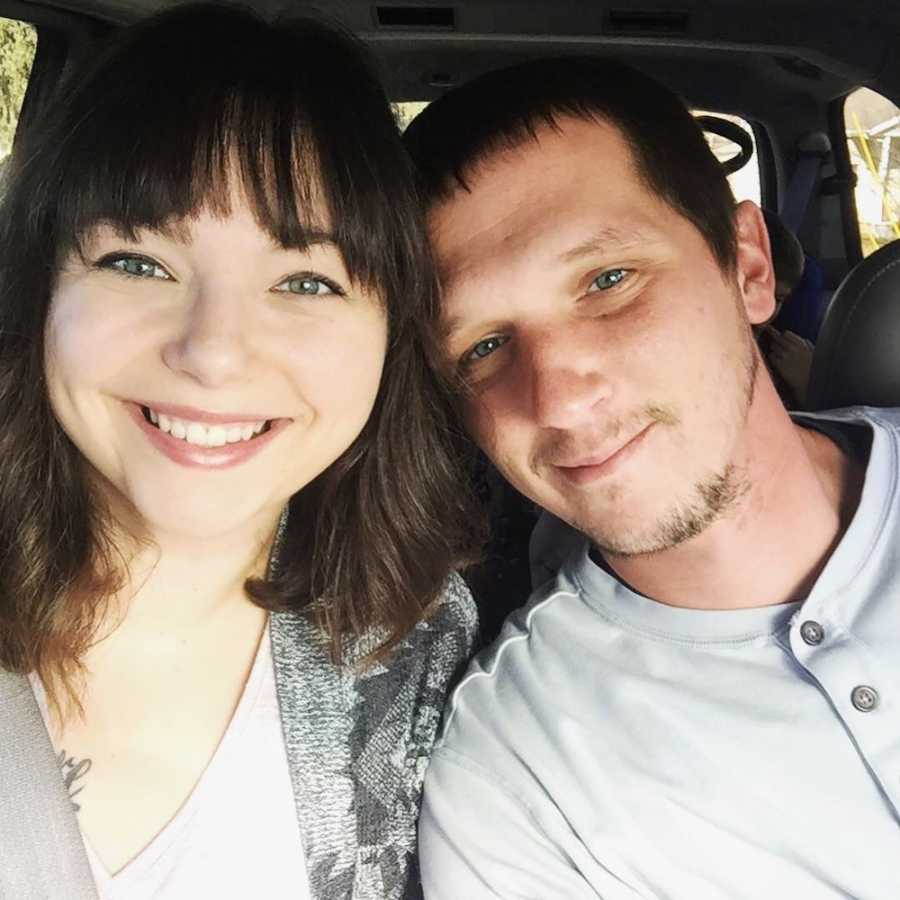 Husband and wife smile in car in selfie