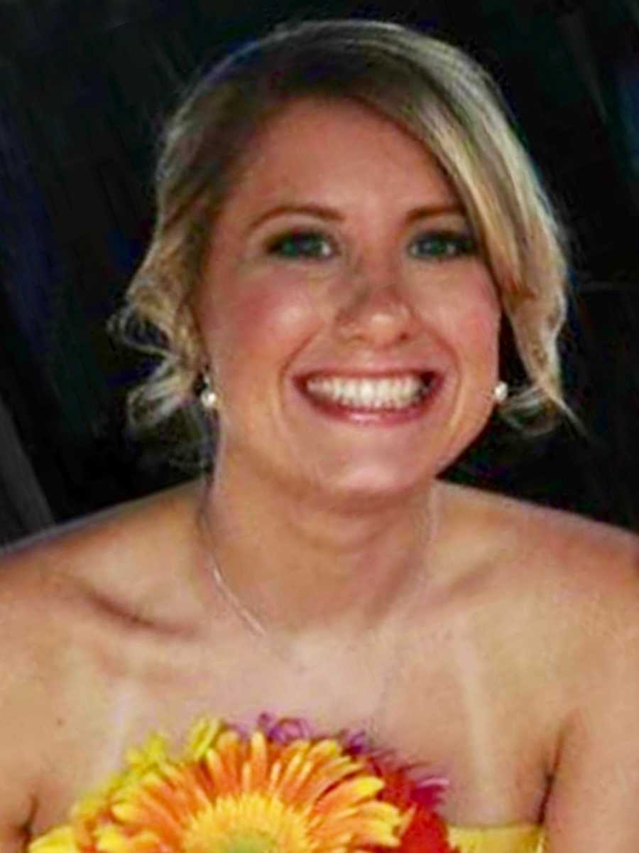 Woman who has since passed from cancer smiles as she holds bouquet of daisies