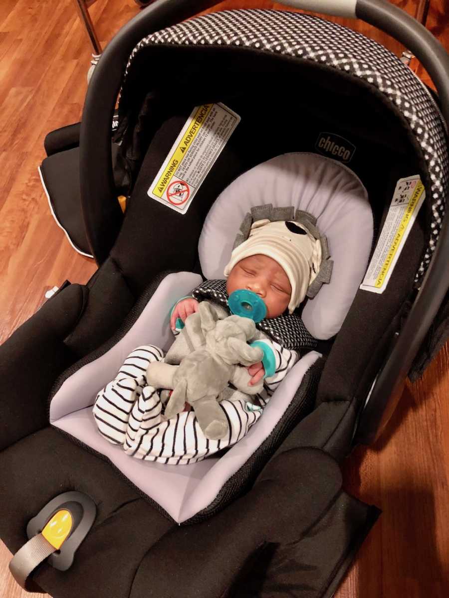 Adopted newborn lays asleep in carseat 