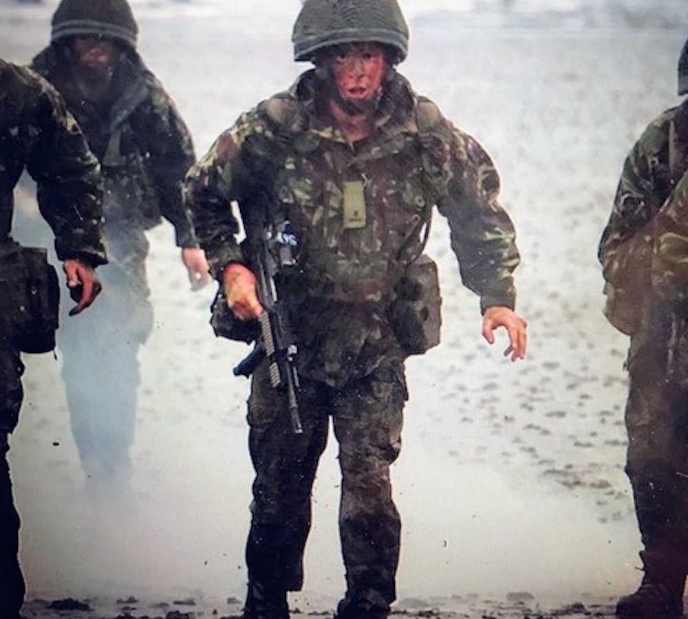 Soldier in uniform runs surrounded by smoke while holding gun