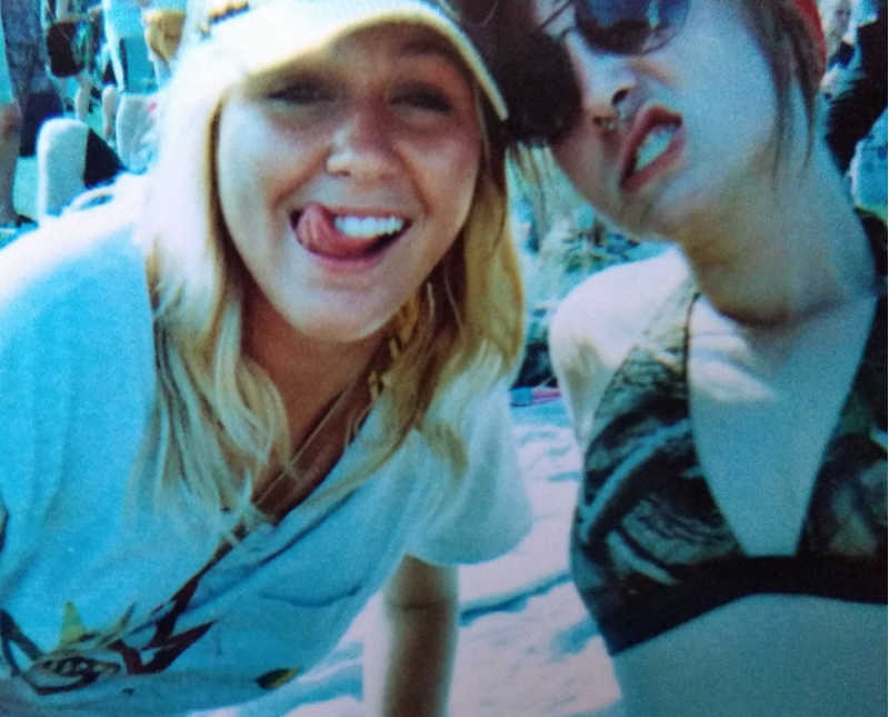 Young woman with alcoholism sticks tongue out beside another teen