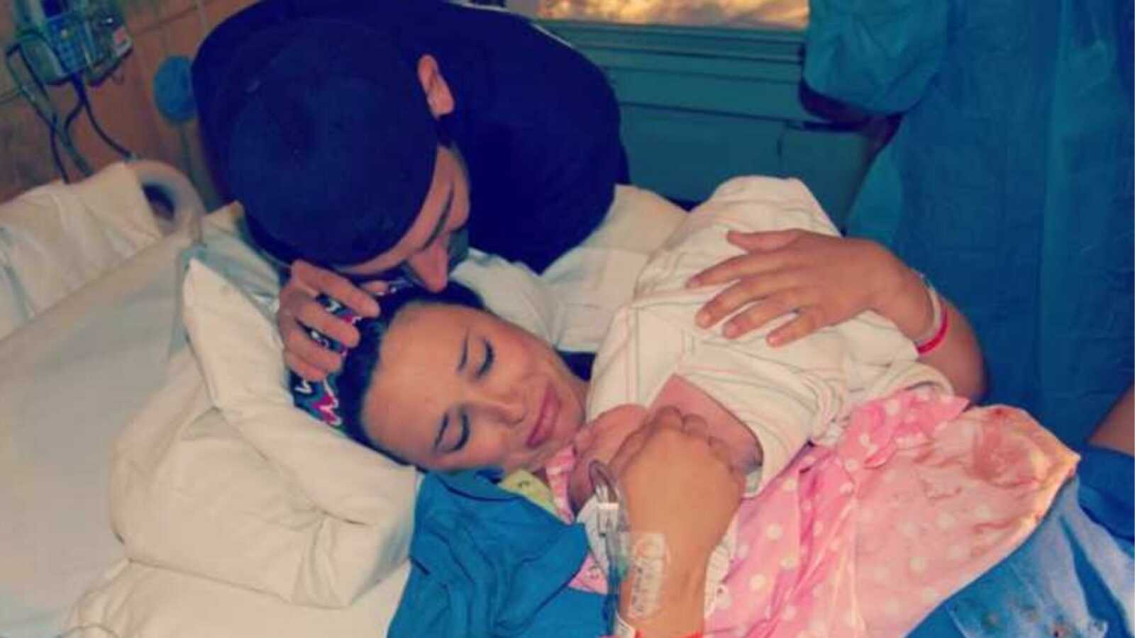 Gun shot survivor cries while holding her newborn child she just birthed