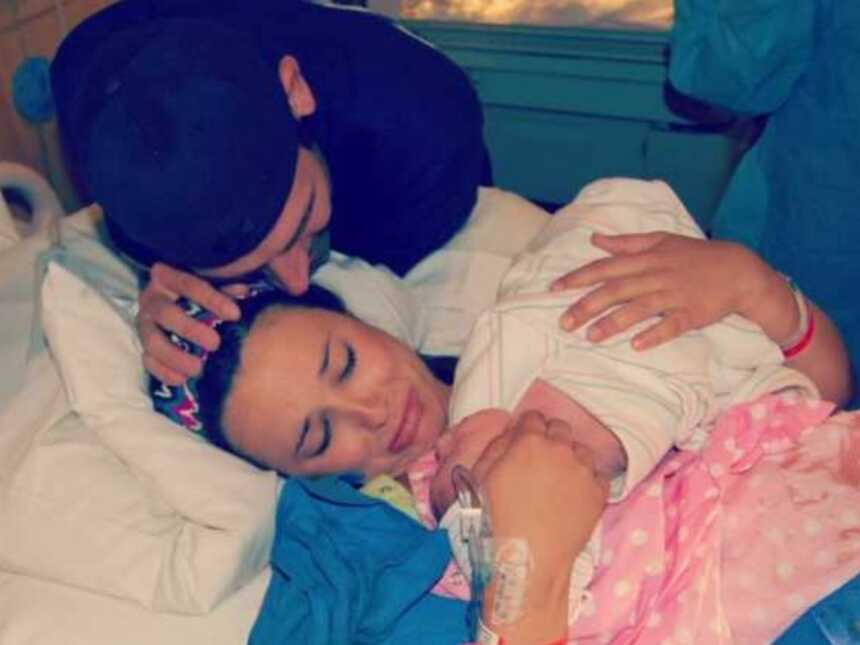Gun shot survivor cries while holding her newborn child she just birthed