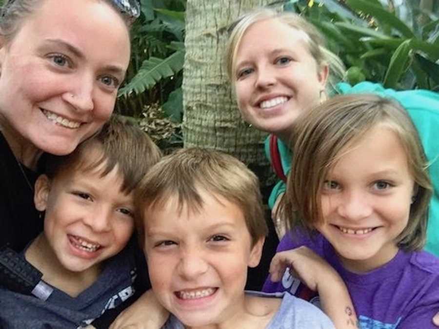 Mother smiles with her three children and girlfriend