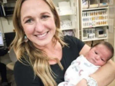 Woman smiles with adopted newborn in her arms