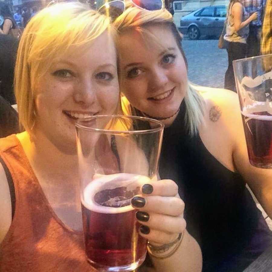 Sisters smile in selfie while holding up their glasses of beer