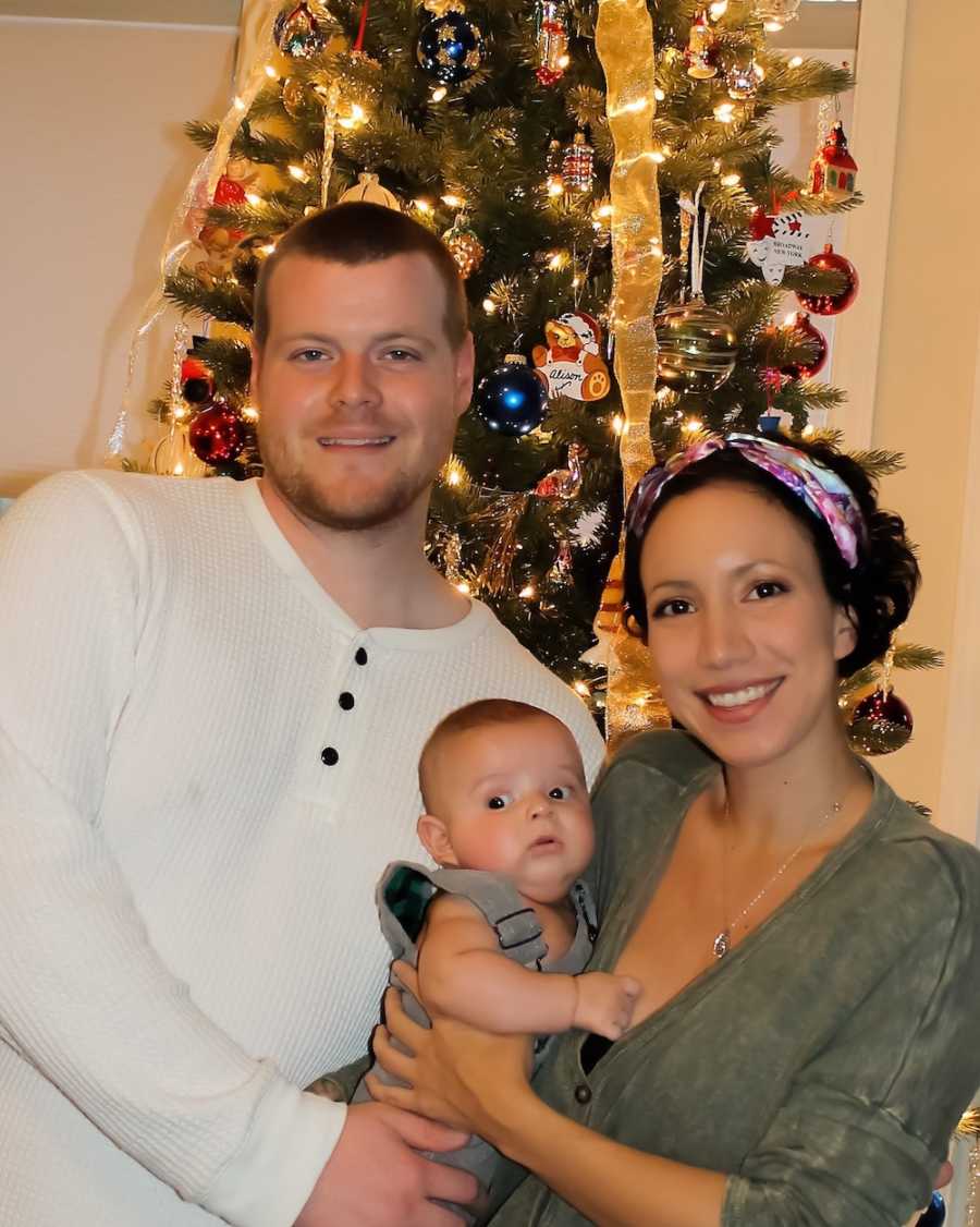 Woman who gave up drugs to have baby stands in front of Christmas tree holding baby and his father