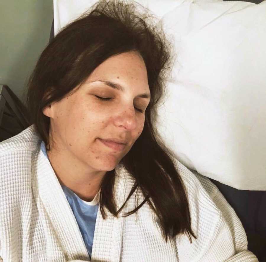 Woman who miscarried lays with her eyes closed
