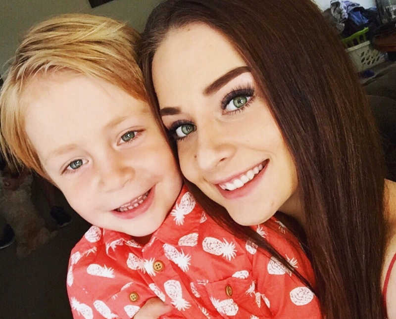 Single mother smiles in selfie with her young son