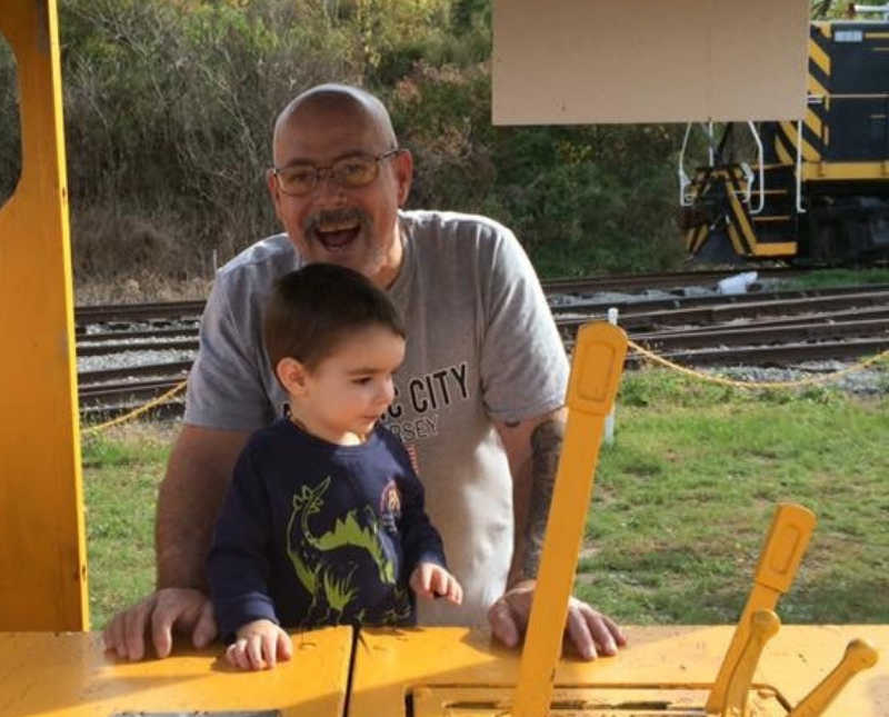 Man who is an addict stands outside with his grandson