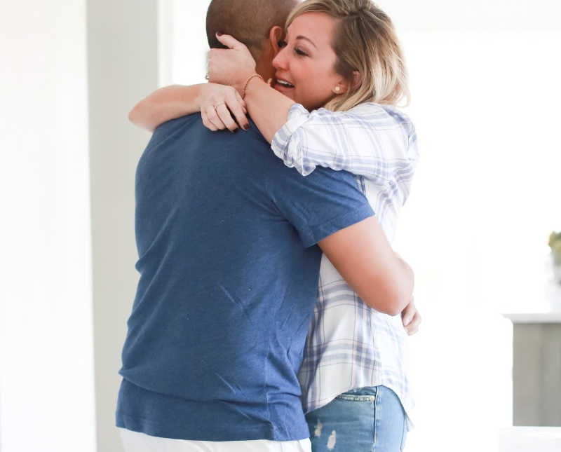 Husband and wife hug as they receive news that they have an egg donor