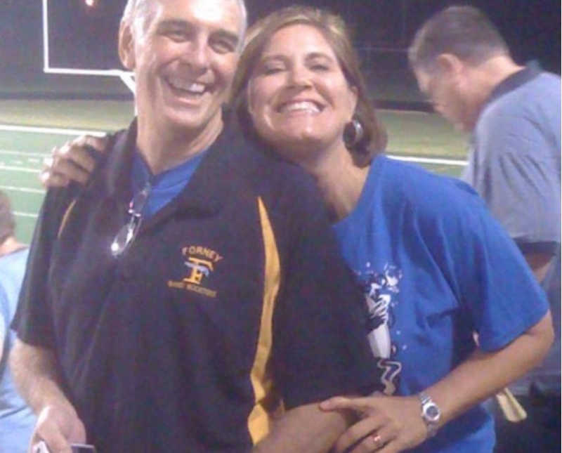 Husband who has since passed stands beside wife at high school football stadium