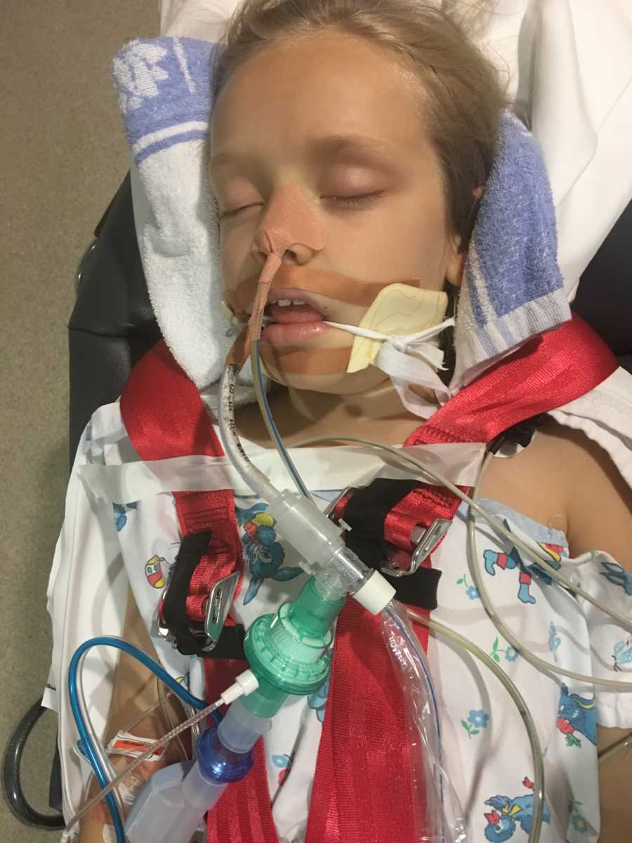 Little girl lays on stretcher in coma with tube down her throat