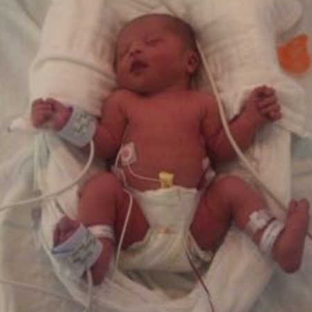 Newborn lays on back in NICU hooked up to monitors