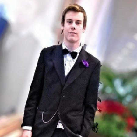 Teen with personality disorder stands smiling in suit