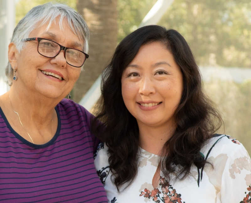 Korean woman stands beside mother who adopted her at birth