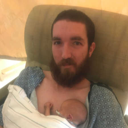 Father smiles as he sits in NICU with newborn asleep on his chest