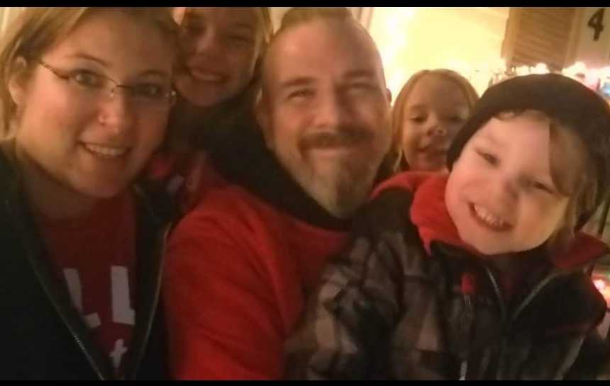 Woman smiles in selfie with her boyfriend and three kids