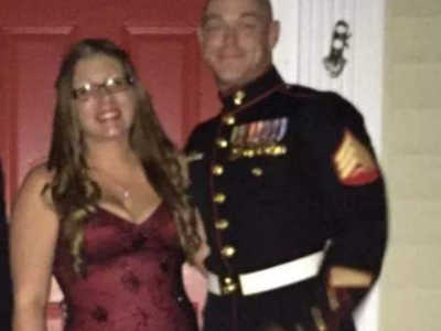Woman stands in formal dress beside soldier husband in front of their front door