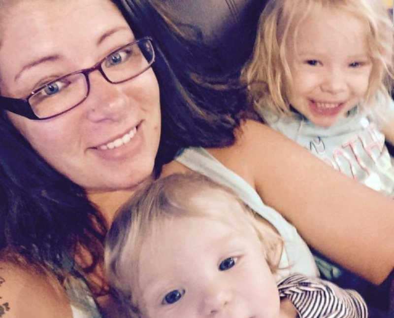 Woman who has been abused smiles in selfie with her two kids
