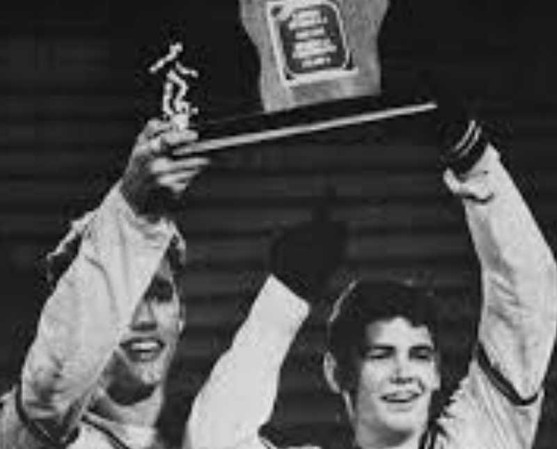 Teen who has since passed stands beside another teen as they hold up soccer trophy