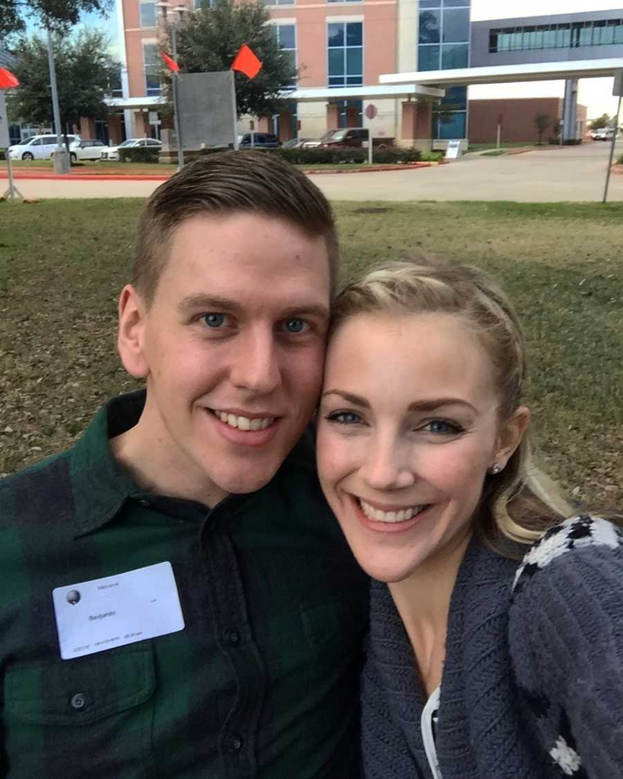 Husband and wife smile in selfie outside of hospital where their adopted son was born