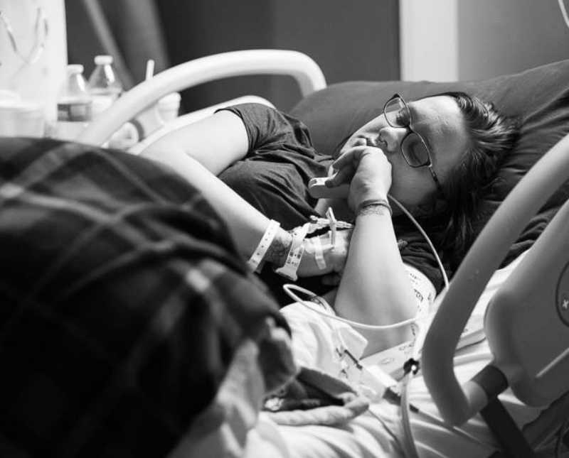 Pregnant woman lays asleep in hospital bed