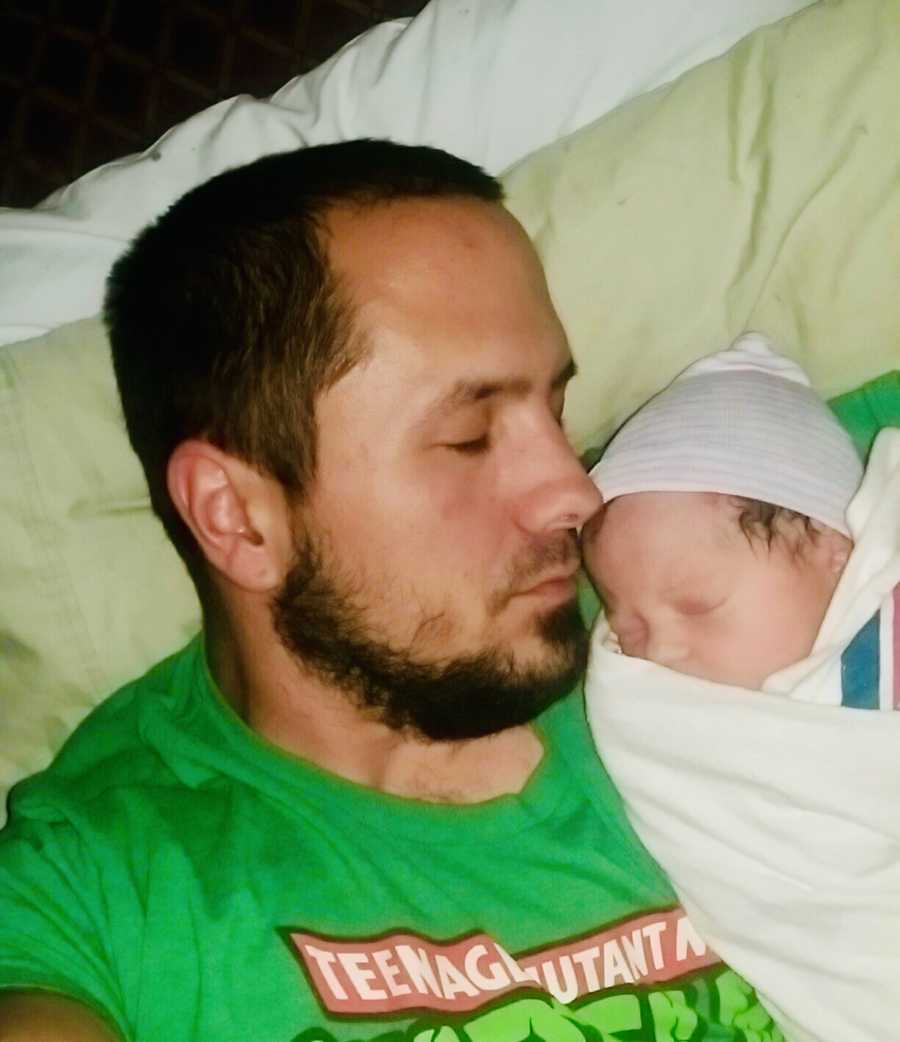 Father sleeps with newborn at his side