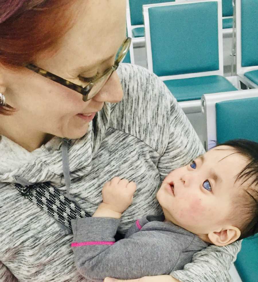 Woman smiles as she looks down at her blind and deaf daughter she adopted