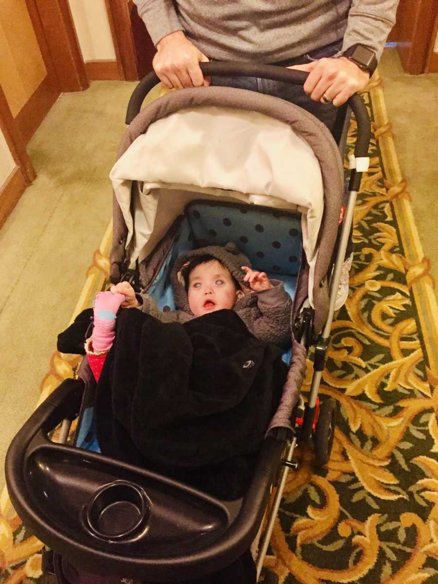 Baby who is deaf and blind lays on her back in stroller