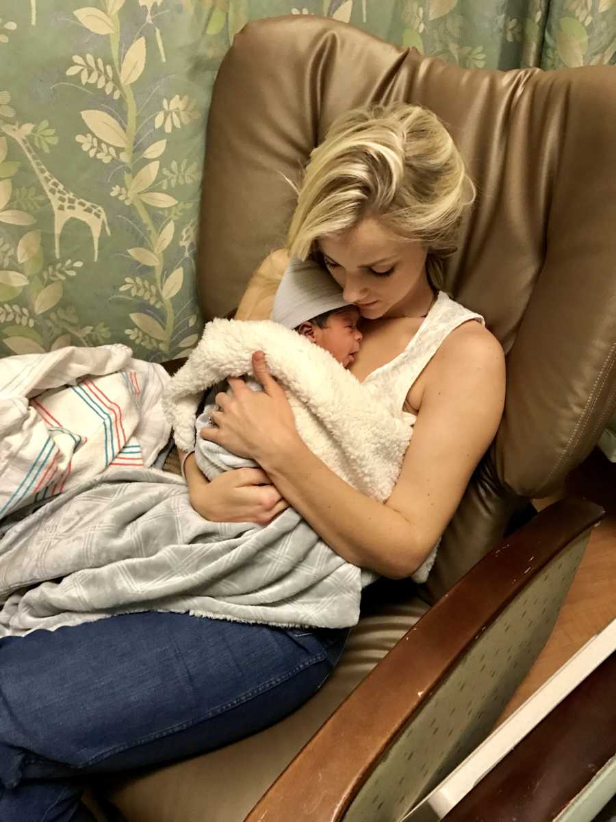 Woman sits in hospital chair holding adopted newborn son tight to her chest