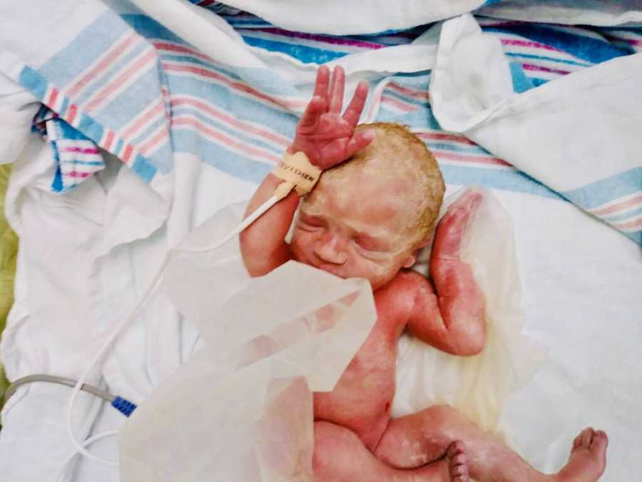 Newborn lays on her back with eyes closed