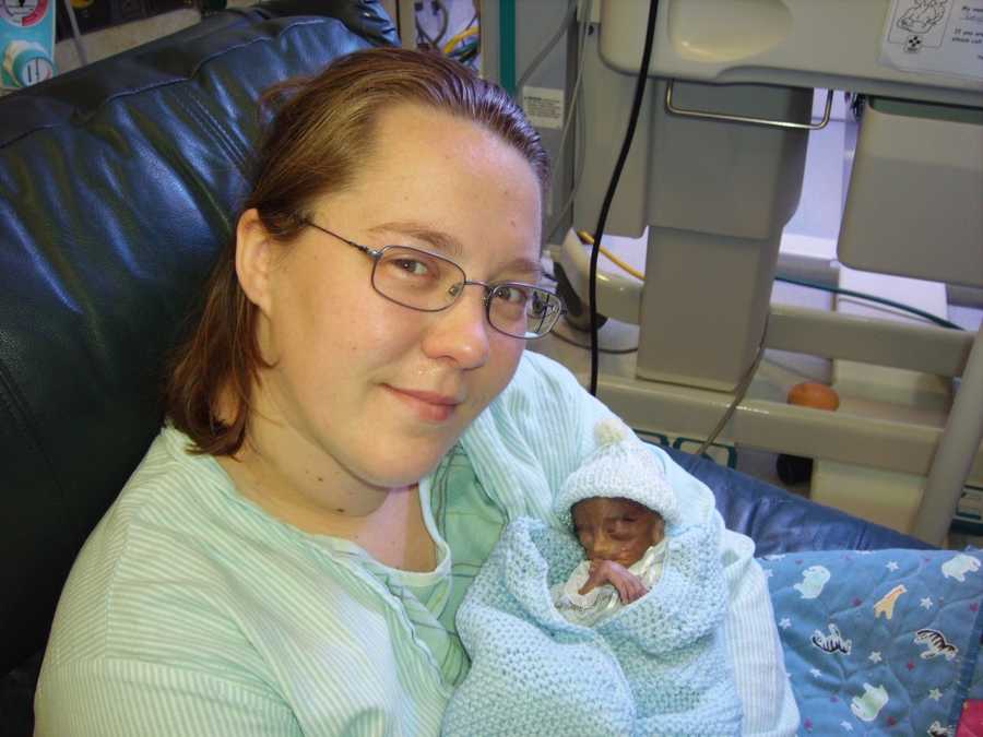 Mother smiles as she sits in NICU holding preemie twin that wouldn't make it