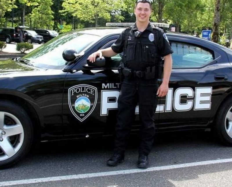 Man who worked for US forest service and as cop stands outside smiling beside police car