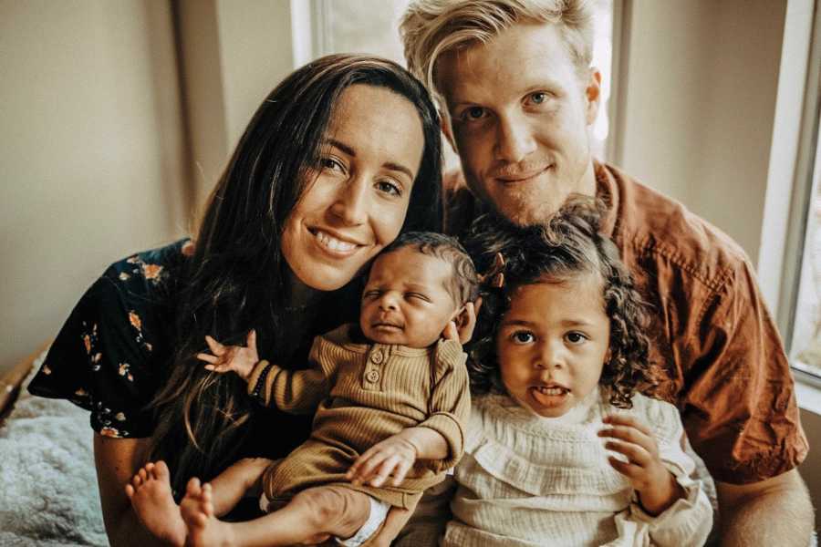 Husband and wife smile with their two adopted children