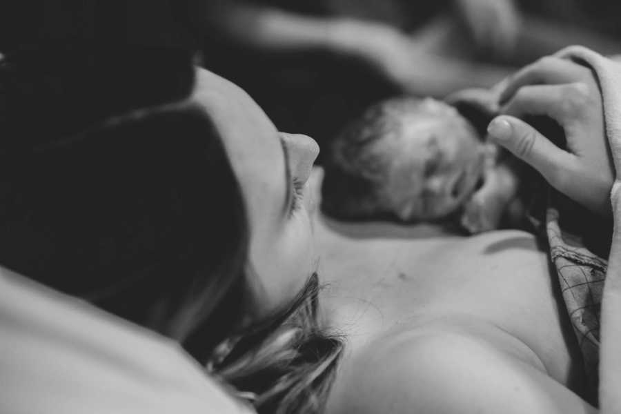 Newborn lays on shirtless mother's chest