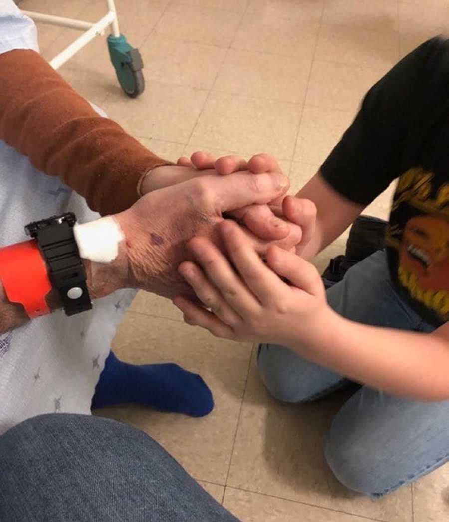 Close up of man in hospital's hands holding grandson's