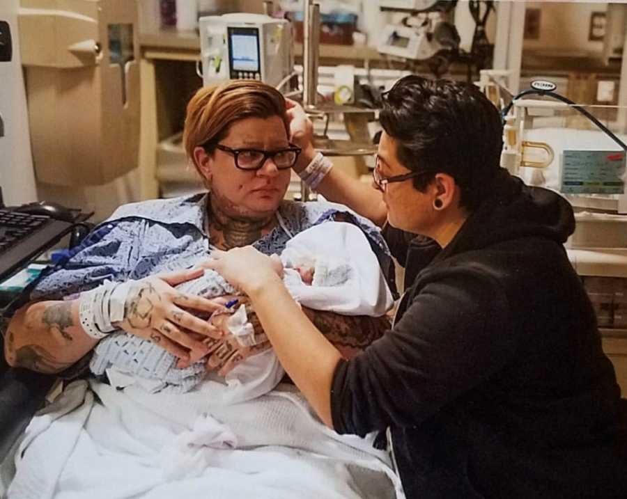 Woman sits in NICU holding newborn who won't live long while her wife kneels beside her