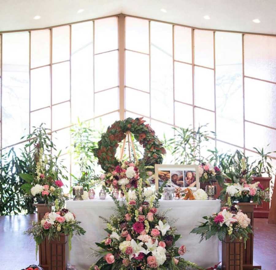 Table surrounded in flowers and picture frames of wives lost children