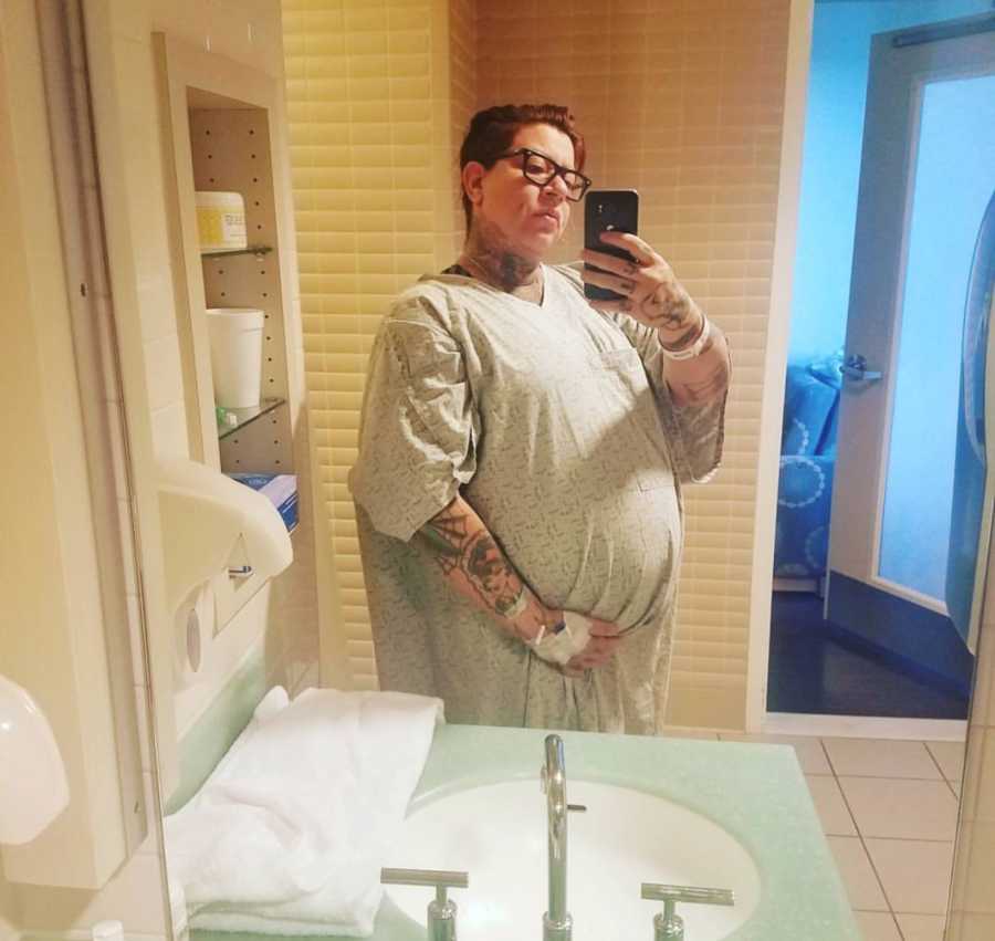 Pregnant woman takes mirror selfie in hospital bathroom