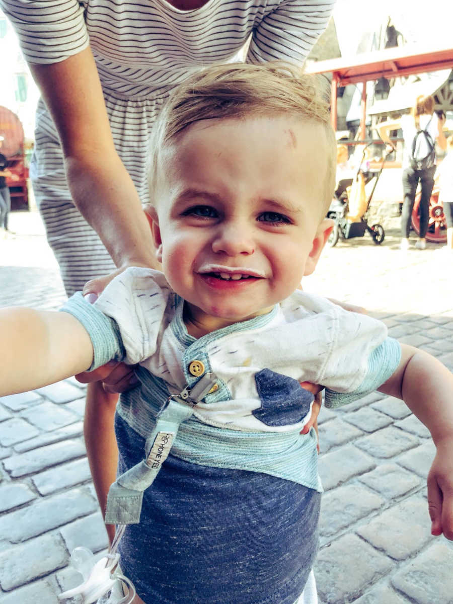 Little boy stands smiling who aunt and uncle love spending time with after losing their child