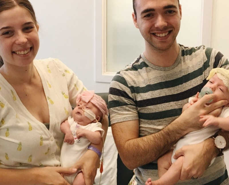 Wife holds intubated twin who had heart surgery beside husband who holds other twin