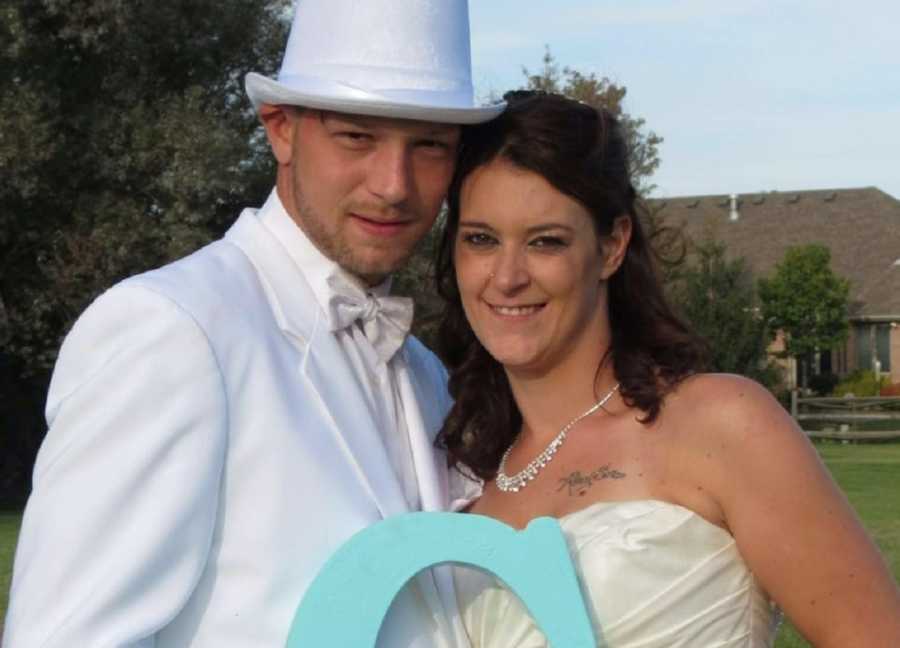 Bride and groom stand smiling outside