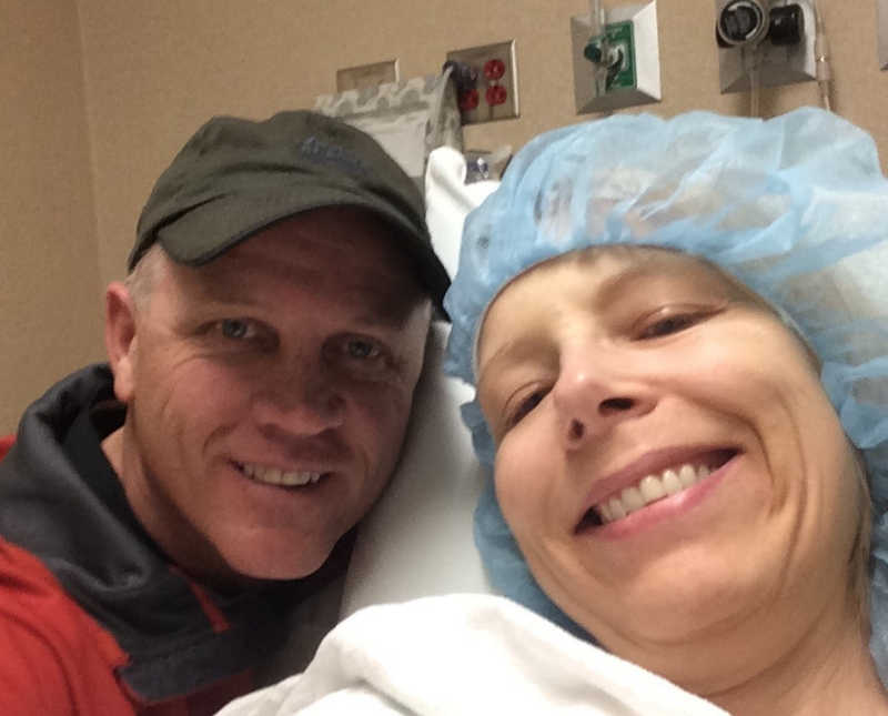 Woman with Gastroparesis lays in hospital bed smiling in selfie with boyfriend