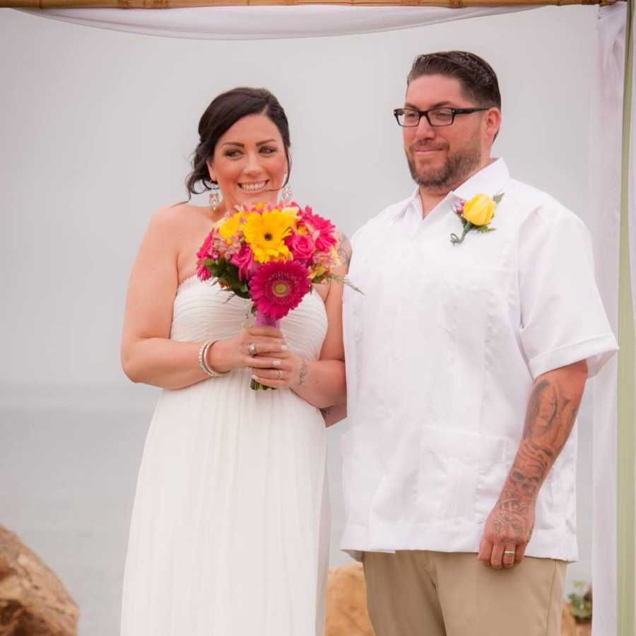 Bride and groom stand smiling 