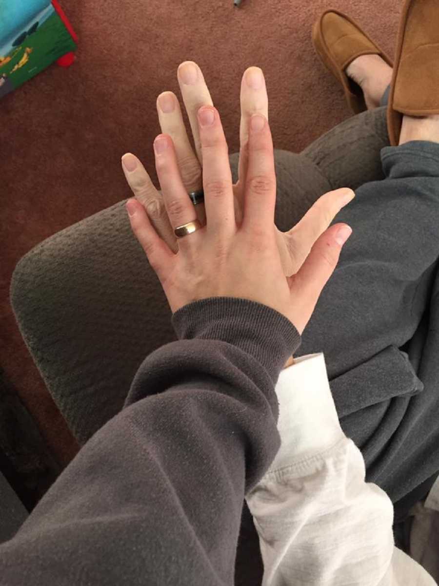 Married woman's hand resting on top of father's hand who has since passed away