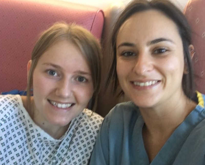 Bride smiles beside bride who is undergoing fertility treatment