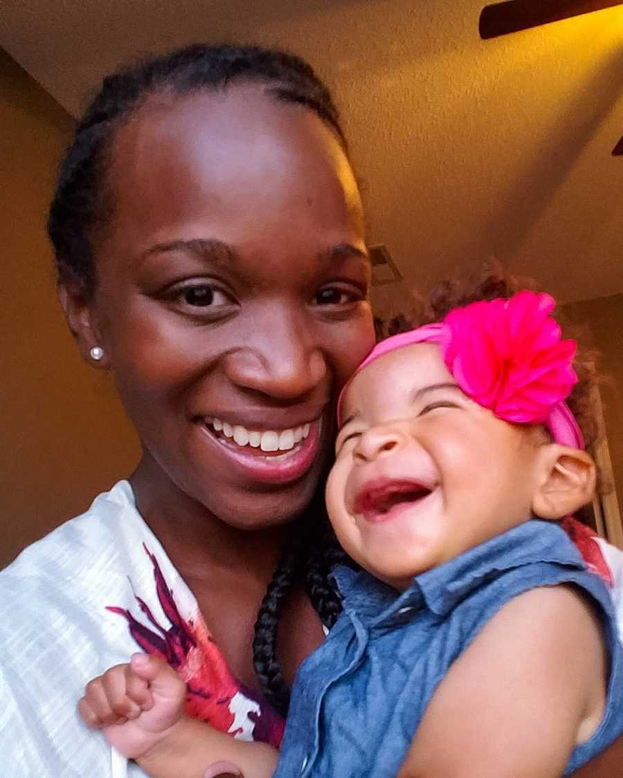 Mother smiles in selfie while holding baby girl with heart issues and prosthetic eyes