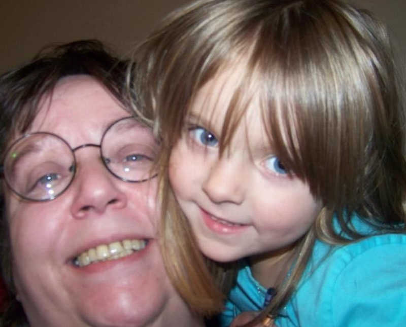Woman smiles in selfie with granddaughter